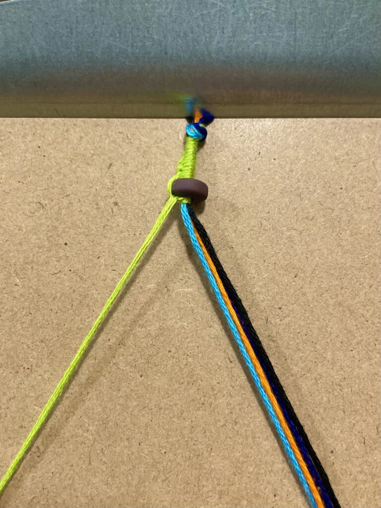 Figure 11. Step 12: Add the first goal bead, then secure it with a green left-hand knot.