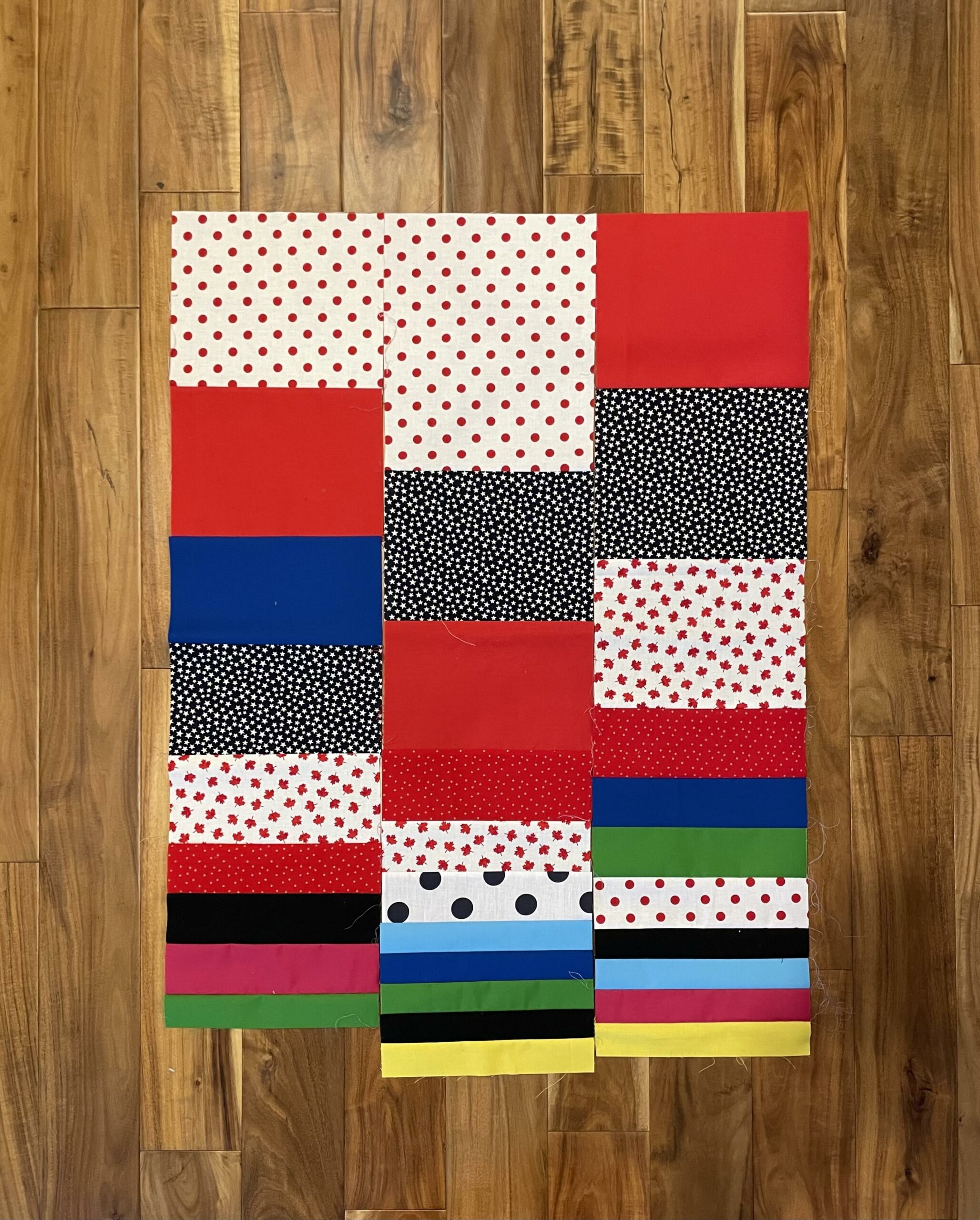 Three columns of sewn fabrics are laid out side-by-side on a wood floor, demonstrating that their lengths are not equal.