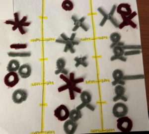 This data physicalization is a vertical timeline over the course of three days. Symbols made from pipe cleaners are added at various times to show what the student was doing when biting/picking at their nails