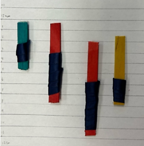 This data physicalization is similar to a bar graph with time represented on the y-axis and days represented on the x-axis. The length of popsicle sticks denotes the amount of time slept. Each wrapped with a black ribbon to also indicate restfulness. 