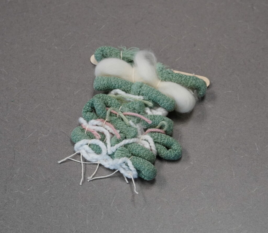 The tapestry has been flipped over. The ragged ends are tucked into the warp threads.