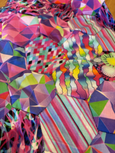 The entire image is taken up with fabric hexagons. Small purple stitches hold them together.